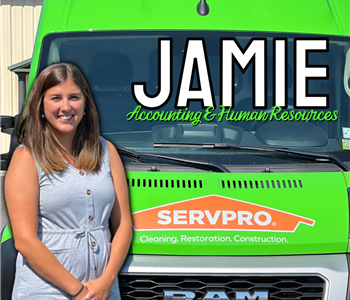 Woman posing in front of green SERVPRO® Van